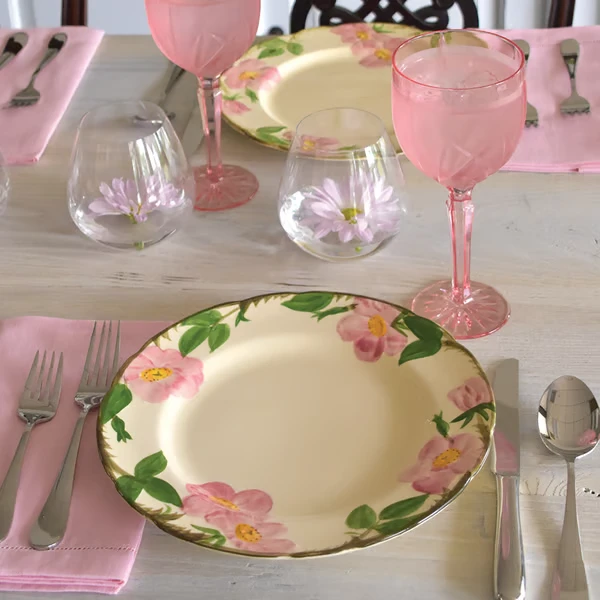 Replacements catalogue styling photograph of Desert Rose plates with pink table linens and glassware